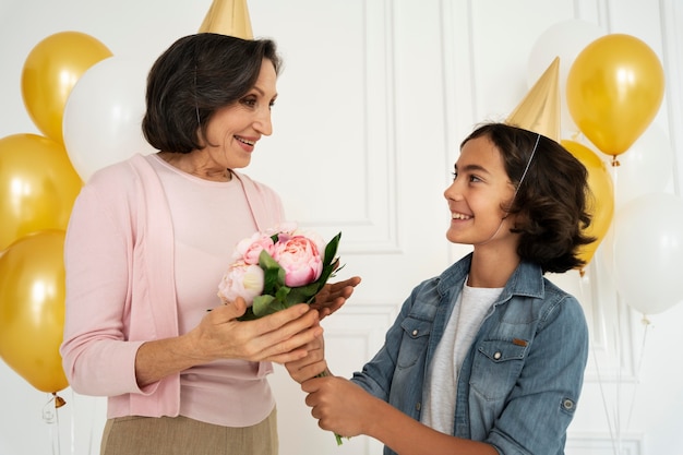 Foto gratuita niño de tiro medio dando flores