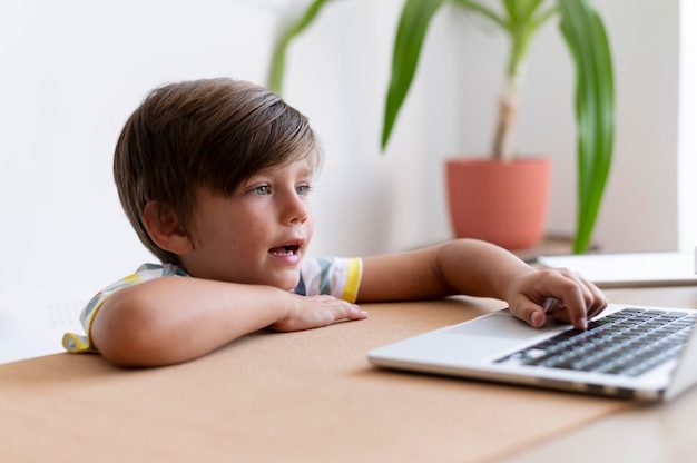 Niño de tiro medio escribiendo en el teclado