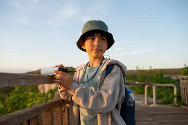 Foto gratuita niño de tiro medio explorando el entorno natural.