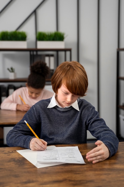 Niño de tiro medio haciendo trampa en el examen escolar