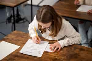 Foto gratuita niño de tiro medio haciendo trampa en el examen escolar