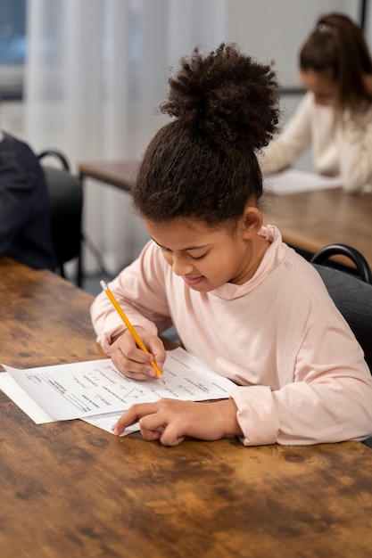 Foto gratuita niño de tiro medio haciendo trampa en el examen escolar