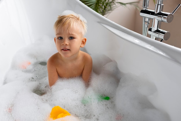 Foto gratuita niño de tiro medio jugando en la bañera