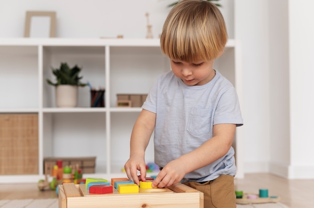 Niño de tiro medio jugando con juguete de madera.