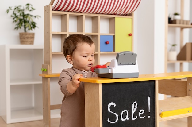 Niño de tiro medio jugando con juguete de madera.