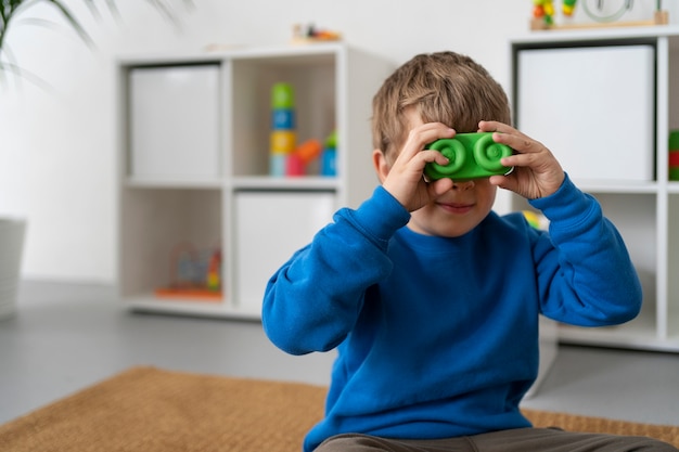 Niño de tiro medio jugando con juguete