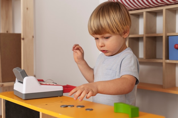 Niño de tiro medio jugando con juguetes