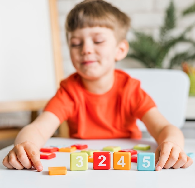 Niño de tiro medio jugando con números