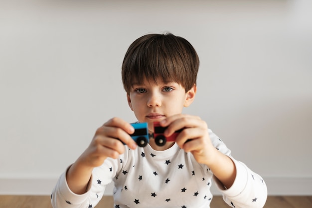 Niño de tiro medio jugando con tren de madera.