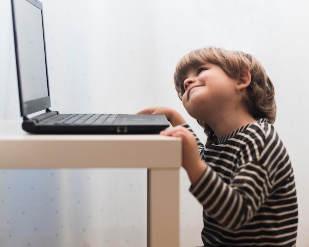 Niño de tiro medio mirando portátil