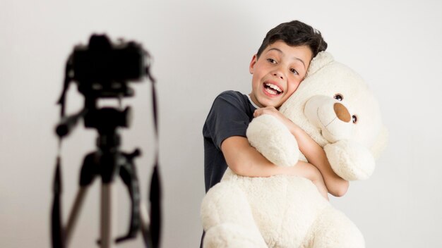 Niño de tiro medio con osito de peluche