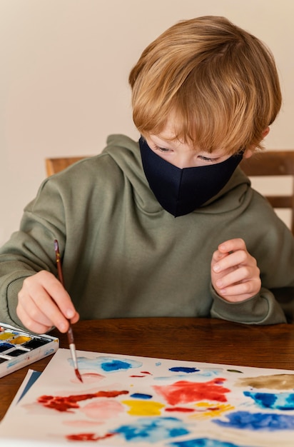 Niño de tiro medio con pintura de máscara