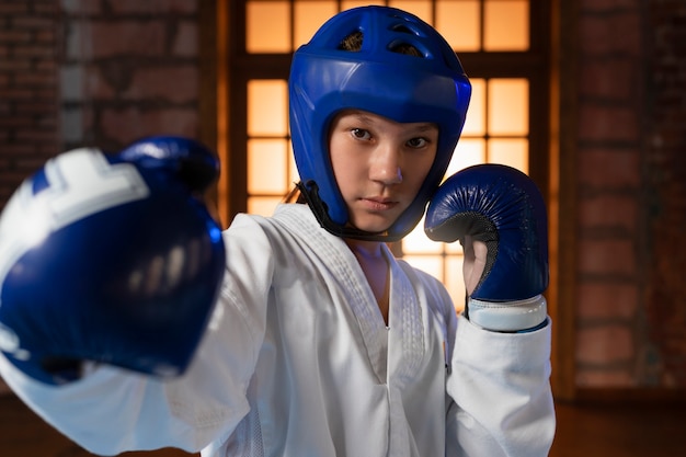 Niño de tiro medio practicando taekwondo