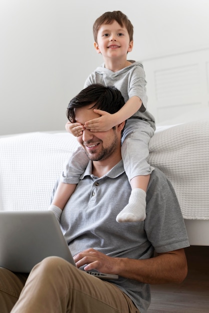 Niño de tiro medio que cubre los ojos del padre