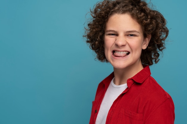 Niño de tiro medio sacando la lengua