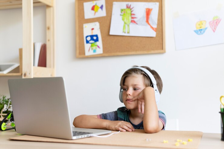 Foto gratuito niño de tiro medio sentado en el escritorio