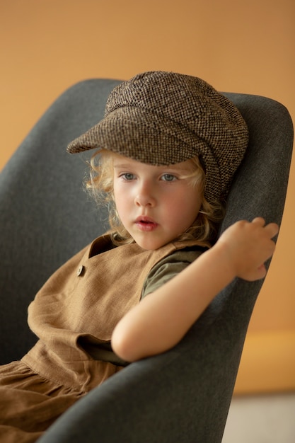 Foto gratuita niño de tiro medio sentado en una silla