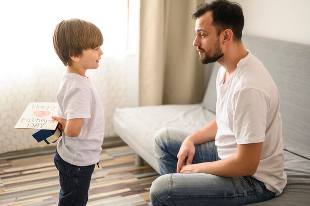 Niño de tiro medio con sorpresa para padre