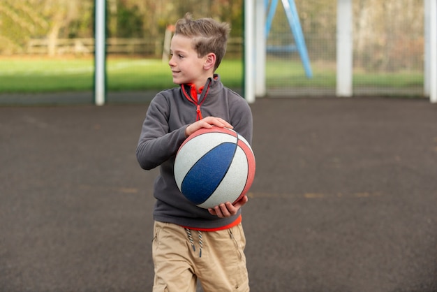 Niño de tiro medio sosteniendo la bola