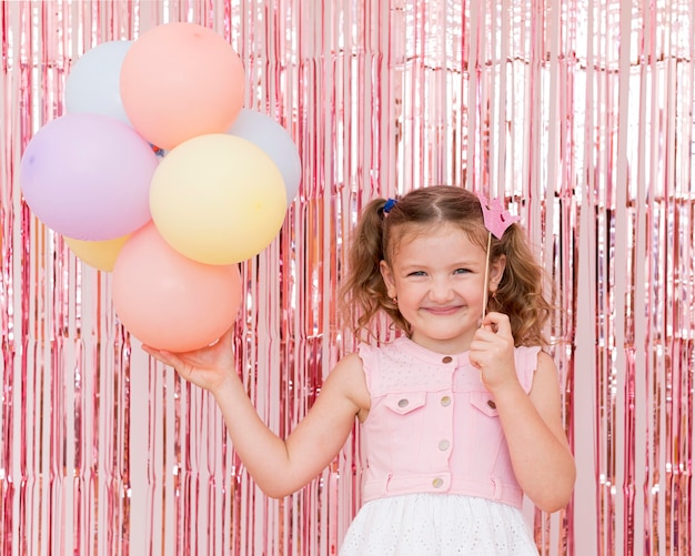 Foto gratuita niño de tiro medio sosteniendo globos