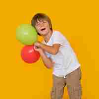 Foto gratuita niño de tiro medio sosteniendo globos