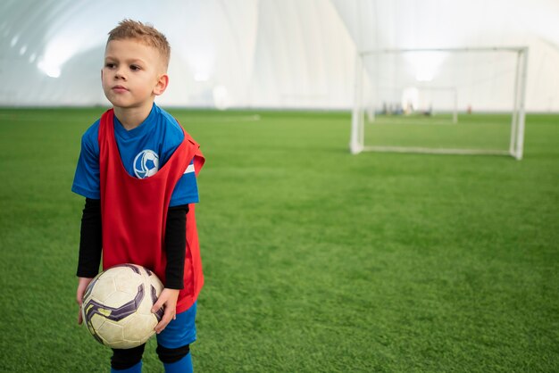 Foto gratuita niño de tiro medio sosteniendo pelota