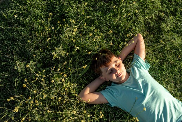 Niño de tiro medio tendido sobre el césped