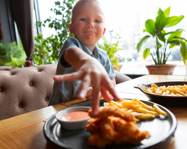 Niño de tiro medio tomando comida