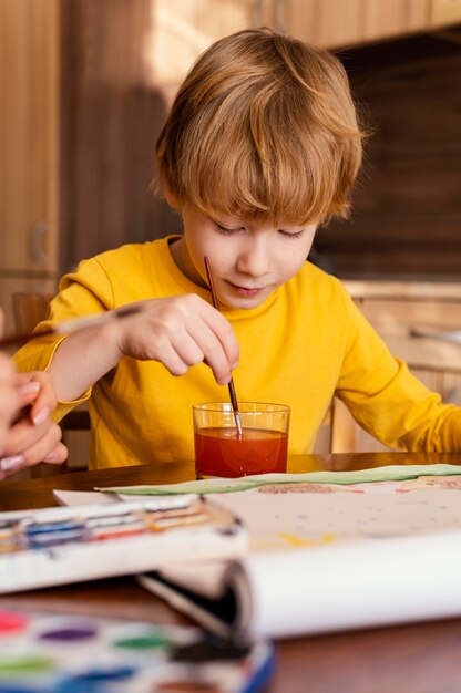 Niño de tiro medio usando acuarelas