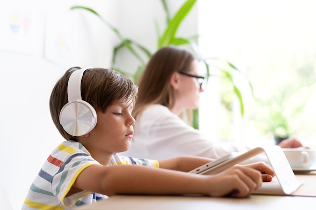 Foto gratuita niño de tiro medio usando audífonos