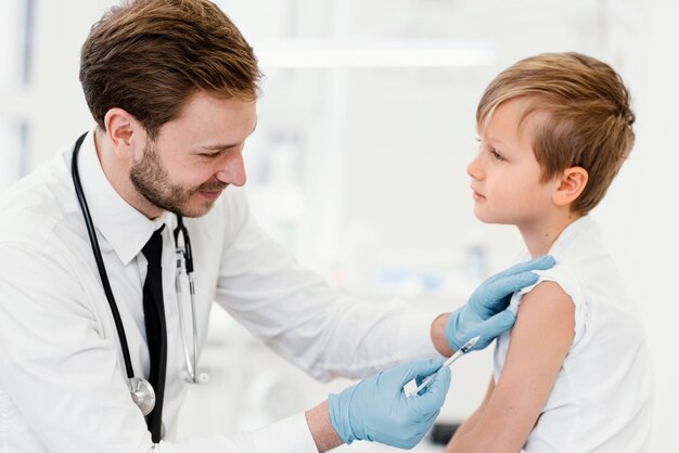 Niño de tiro medio vacunándose