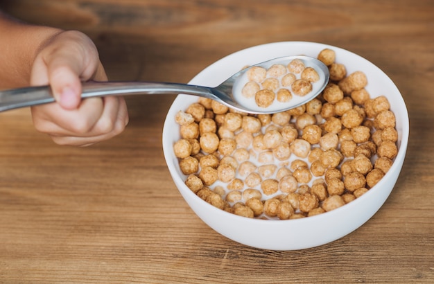 Foto gratuita niño tomando una cucharada de cereal