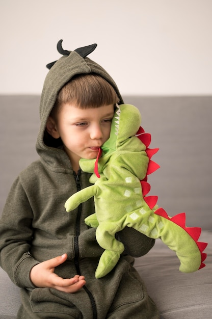 Foto gratuita niño en traje de dinosaurio jugando