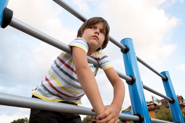 Niño triste de ángulo bajo en el parque