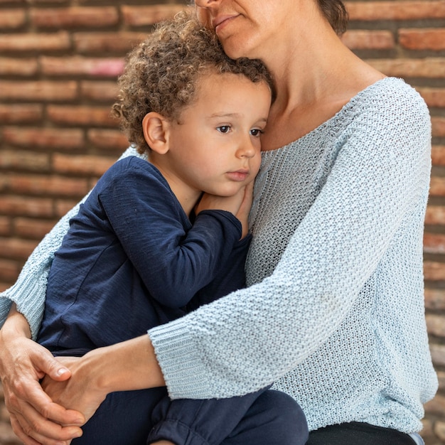 Niño triste consolado por su madre