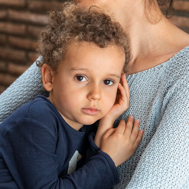 Niño triste consolado por su madre