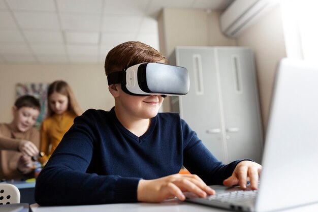 Niño usando una computadora portátil y gafas vr