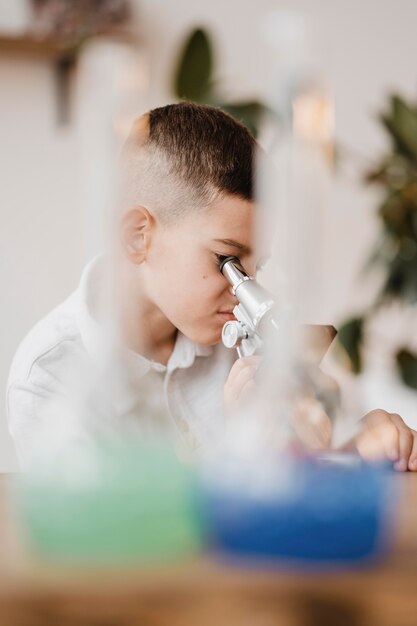 Niño usando un microscopio para aprender ciencia