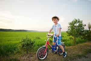 Foto gratuita niño use sombrero en bicicleta momentos de niños felices