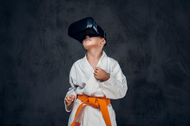 Niño vestido con un kimono blanco con gafas VR en la cabeza.