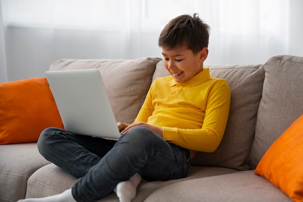 Foto gratuita niño viendo películas en la computadora portátil