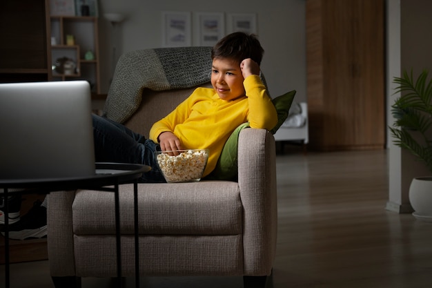 Foto gratuita niño viendo películas en la computadora portátil