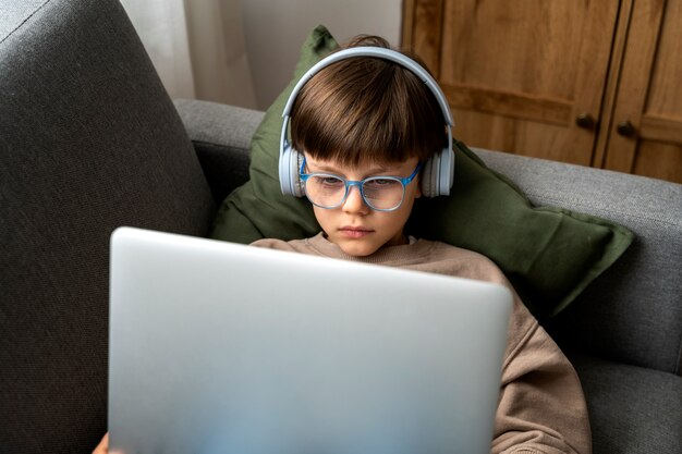 Niño viendo películas en la computadora portátil