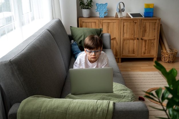 Niño viendo películas en la computadora portátil