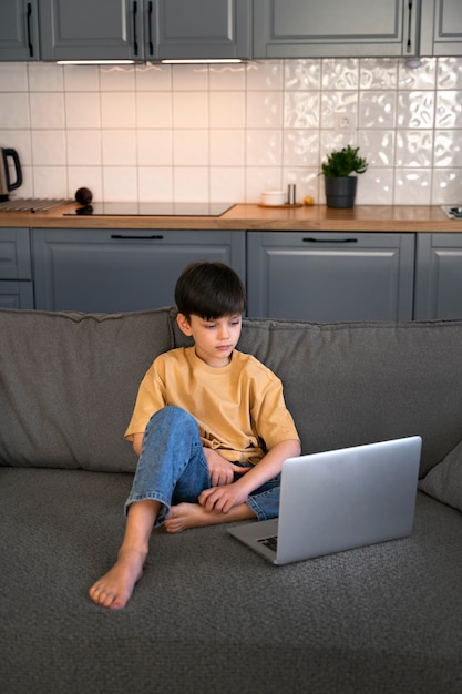 Foto gratuita niño viendo películas en la computadora portátil