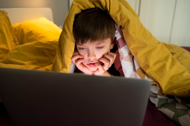 Niño viendo películas en la computadora portátil