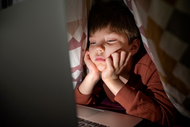 Foto gratuita niño viendo películas en la computadora portátil