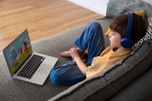 Niño viendo películas en la computadora portátil