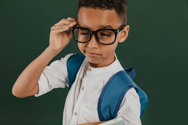 Foto gratuita niño de vista frontal con gafas de lectura