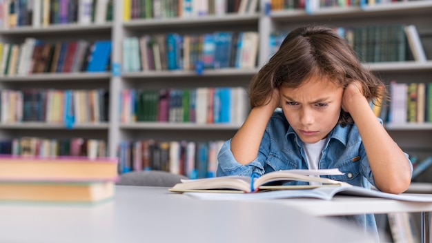 Niño de vista frontal pensando en cómo resolver su tarea con espacio de copia